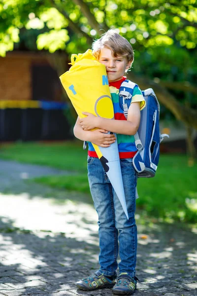 Petit garçon enfant avec cartable scolaire le premier jour à l'école, tenant le cône de l'école avec des cadeaux — Photo