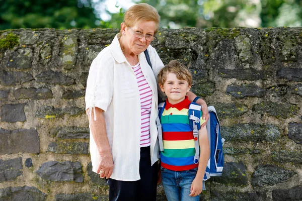 Abuela llevando al niño, niño a la escuela en su primer día — Foto de Stock