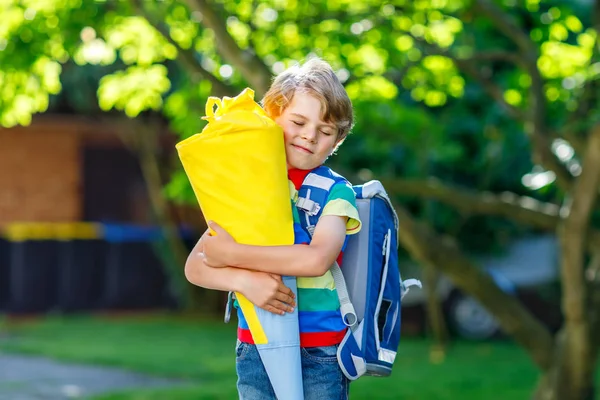 Kid jongetje met school satchel op eerste dag naar school, houden van school kegel met geschenken — Stockfoto