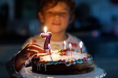 Adorable happy blond little kid boy celebrating his 7 birthday. clipart