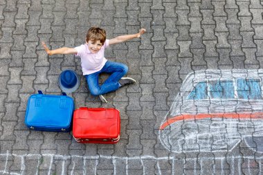 Küçük çocuk çocuk hızlı tren resim ile renkli tebeşirler asfalt üzerinde çizim ile eğleniyor