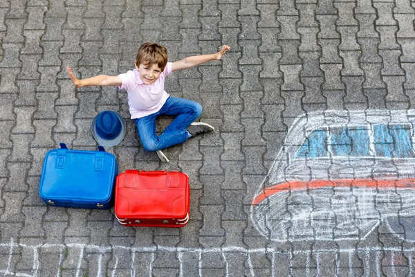 Menino pequeno que se diverte com desenho rápido da imagem do trem com giz colorido no asfalto — Fotografia de Stock