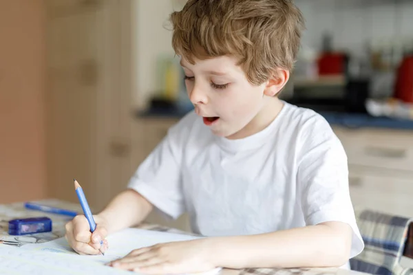 Joyeux écolier garçon à la maison faire des devoirs — Photo