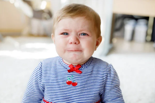 Niedliches kleines trauriges Mädchen weint. hungriges oder müdes Kind, das drinnen sitzt und Tränen hat — Stockfoto