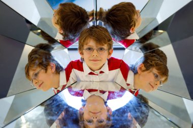 Küçük çocuk çocuk bir musem aynalar ile deneyler ile eğleniyor. Mutlu gülümseyen okul çocuk portresi.