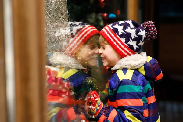 Komik mutlu çocuk moda kış giysileri pencere alışveriş yapma hediyeler, xmas ağacı ile dekore edilmiştir. — Stok fotoğraf