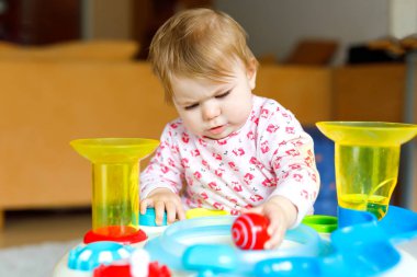 Eğitici oyuncaklar Evde çocuk odası oynayın sağlıklı sevimli güzel küçük bebek kız. Mutlu sağlıklı çocuk renkli yumuşak oyuncaklar ile eğleniyor. Çocuk farklı becerileri öğrenme.