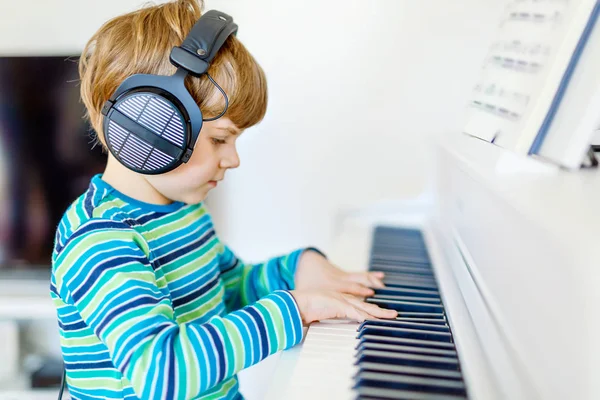 Oturma odası veya müzik okulu piyano sağlıklı küçük çocuk yakışıklı. Okul öncesi çocuk müzik enstrüman çalmak öğrenme ile eğleniyor. Eğitim, Beceri kavramı — Stok fotoğraf