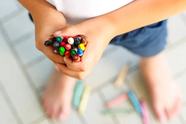 Närbild av childs händer med massor av färgglada vax kritor pennor. Kid förbereder skolan och dagis utrustning och student grejer. Tillbaka till skolan. Utbildning, skola, lärande koncept.. — Stockfoto