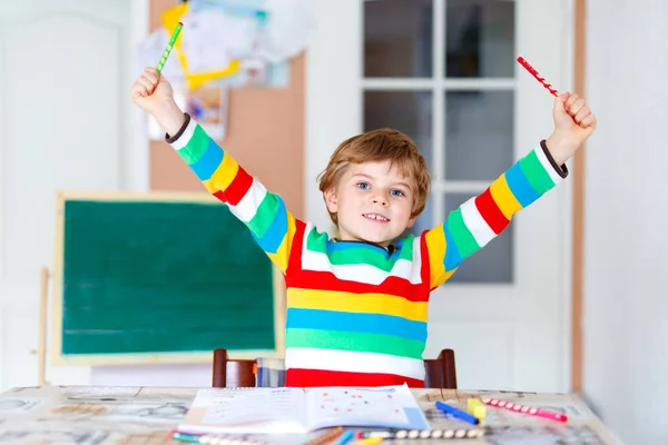 Potret lucu bahagia anak sekolah anak di rumah membuat pekerjaan rumah. Anak kecil menulis dengan pensil berwarna-warni, di dalam ruangan. Sekolah dasar dan pendidikan — Stok Foto