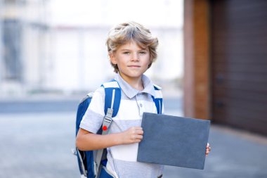 Mutlu çocuk ufaklikla sırt çantası veya el çantası. Temel okul yolu üzerinde. Açık havada boşaltmak için boş tebeşir masası ile sağlıklı sevimli çocuk. Okula dönüş.