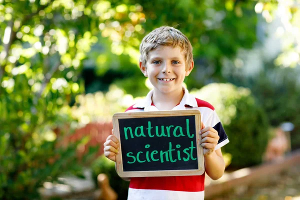 Happy little kid boy with chalk desk in hands. Healthy adorable child outdoors On desk - natural scientist - in German as dream profession of beautiful schoolkid — Stock Photo, Image