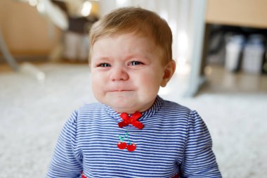 Sevimli küçük üzgün bebek kız ağlıyor. Kapalı oturma ve sahip yorgun ya da aç çocuk gözyaşları