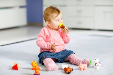 Sevimli bir bebek inek, at, koyun, köpek ve zürafa, fil ve maymun gibi vahşi hayvanlarla oynuyor. Mutlu sağlıklı çocuk evde renkli oyuncaklarla eğleniyor.