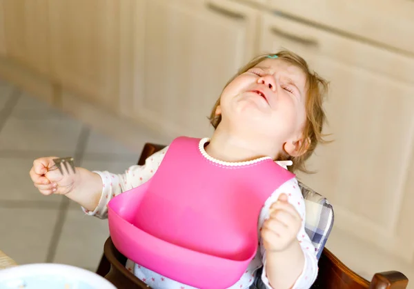 Üzgün Ağlayan bebek kız. Yürümeye başlayan çocuk değil yeme. İsterik çocuk tek başına yemek öğrenme — Stok fotoğraf