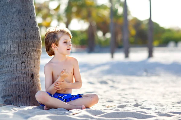 Blond mały chłopiec dziecko zabawy na plaży w Miami, Key Biscayne. Szczęśliwy zdrowe dziecko Ładna gra z piasku i uruchomiona w pobliżu oceanu. Palmy, zabezpieczenia domu i biały piasek — Zdjęcie stockowe