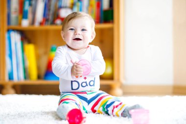 Bebek odasında eğitici oyuncaklarla oynayan sevimli bir kız. Mutlu sağlıklı çocuk evde renkli farklı oyuncaklarla eğleniyor. Bebek gelişimi ve ilk adımlar, çalmayı ve yakalamayı öğrenmek..