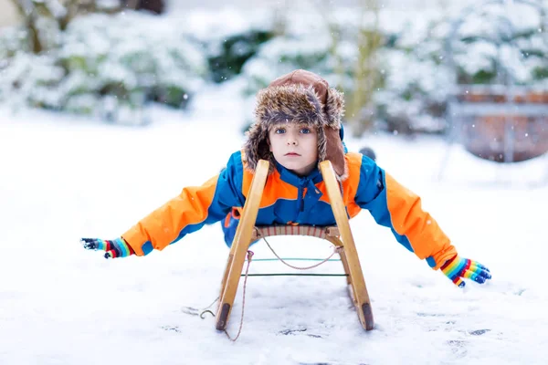 Niño pequeño teniendo fung con paseo en trineo en invierno — Foto de Stock