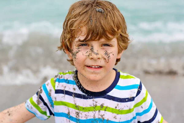 Очаровательный активный мальчик веселится на пляже Майами, Ки Бискейн. Счастливый симпатичный ребенок, отдыхающий, играющий и наслаждающийся бурным теплым днем у пальм и океана. Мальчик с песком на смешном красивом лице . — стоковое фото