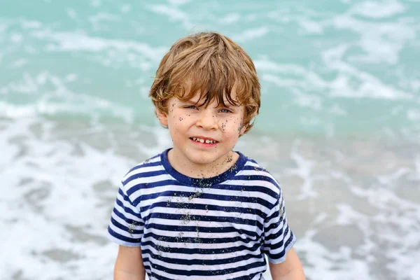 Adorable petit garçon actif qui s'amuse sur la plage de Miami, Key Biscayne. Joyeux enfant mignon relaxant, jouant et profitant d'une journée chaude orageuse près des paumes et de l'océan. Enfant avec du sable sur drôle beau visage . — Photo