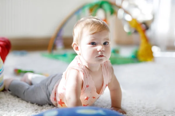 Küçük şirin bebek kız tarama öğrenme. Sağlıklı çocuk çocuk odası renkli oyuncaklar ile kaynıyor. Bebek bacakları arkadan görünüm. Ana sayfa keşfetmek ve farklı becerileri öğrenme şirin bebek — Stok fotoğraf