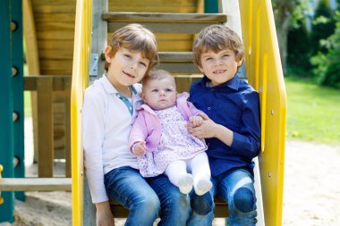 Yeni doğan bebek kız, sevimli kız kardeşi ile iki küçük mutlu bir çocukluk çocuklar. Kardeş oyun yaz veya bahar Anneler gününde üzerinde. Kız bebek kol üzerinde tutarak kardeşim. Bağ çocuklar. Aile üç çocuk.