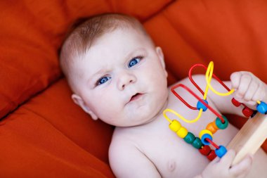 Renkli ahşap eğitim çıngırak oyuncakla oynamak sevimli yeni doğmuş bebek. Yeni doğan çocuk, küçük kız. Aile, yeni bir hayat, çocukluk, başlangıç kavramı.