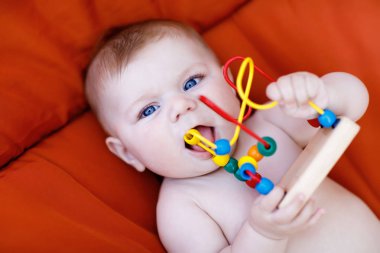 Renkli ahşap eğitim çıngırak oyuncakla oynamak sevimli yeni doğmuş bebek. Yeni doğan çocuk, küçük kız. Aile, yeni bir hayat, çocukluk, başlangıç kavramı.