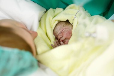 Yeni doğan çocuk saniye ve Genç Anne ve doğumdan sonra dakika. Havlu üzerinde sevimli küçük yeni doğan bebek kız. Yeni hayata başlayan, sağlık,