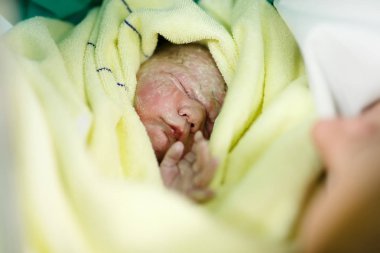 Yeni doğan çocuk saniye ve Genç Anne ve doğumdan sonra dakika. Havlu üzerinde sevimli küçük yeni doğan bebek kız. Yeni hayata başlayan, sağlık,