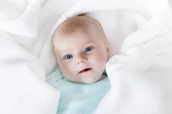 Bonito bebê recém-nascido adorável em cama branca e envolto em cobertor. Criança recém-nascida, menina olhando surpreso com a câmera. Família, nova vida, infância, conceito inicial — Fotografia de Stock