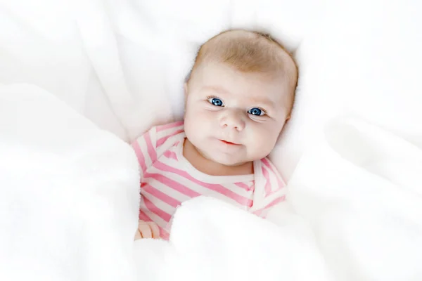 Bonito bebê recém-nascido adorável na cama branca em um cobertor. Criança recém-nascida, menina adorável olhando surpreso com a câmera. Família, nova vida, infância, conceito inicial — Fotografia de Stock