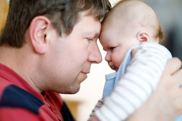 Feliz padre joven orgulloso divirtiéndose con la hija recién nacida, retrato familiar juntos. Papá con la niña, amor. Niño recién nacido mirando a papá. Vinculación, familia, nueva vida —  Fotos de Stock