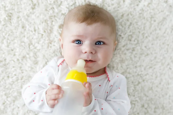 Schattig schattige ewborn baby meisje met borstvoeding fles en drinken formule melk. Eerste voedsel voor baby 's. Pasgeboren kind, klein meisje op een witte achtergrond. Familie, nieuw leven, kindertijd, fles — Stockfoto