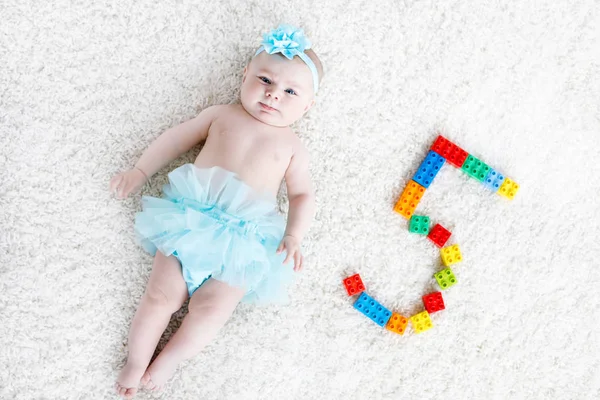 Söt liten flicka på vit bakgrund bär turkos tutu kjol. Söta små barn skrattar och ler. Glad bekymmerslös bebis. Barndom, nytt livskoncept.. — Stockfoto