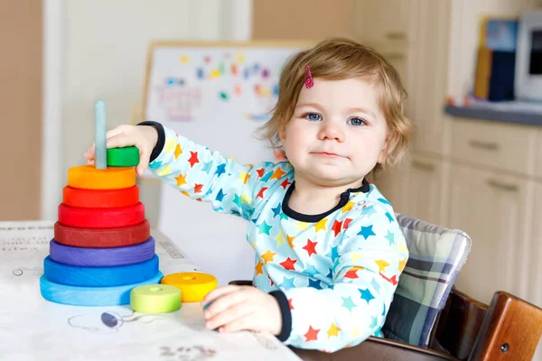 Entzückend süße schöne kleine Mädchen spielen mit Lernspielzeug zu Hause oder im Kinderzimmer. Glückliches gesundes Kind, das Spaß an der bunten hölzernen Regenboy-Spielzeugpyramide hat. Kind lernt andere Fähigkeiten. — Stockfoto