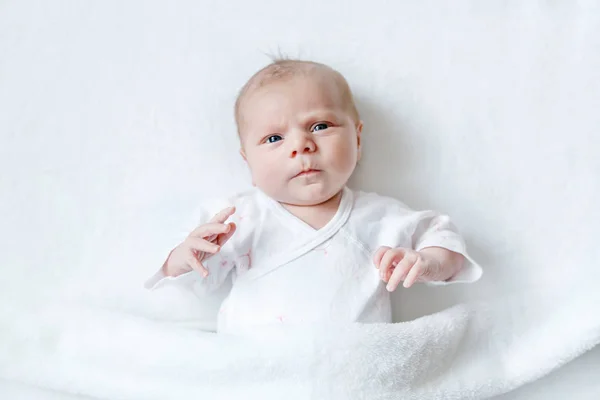 Lindo bebé recién nacido adorable en cama blanca y envuelto en manta. Niño recién nacido, niña mirando sorprendida a la cámara. Familia, nueva vida, infancia, concepto inicial — Foto de Stock