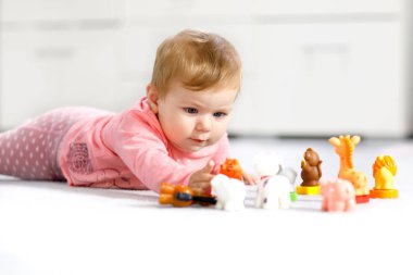 Sevimli bir bebek inek, at, koyun, köpek ve zürafa, fil ve maymun gibi vahşi hayvanlarla oynuyor. Mutlu sağlıklı çocuk evde renkli oyuncaklarla eğleniyor.