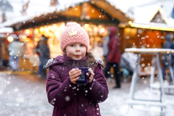 小可爱的女孩与一杯热气腾腾的巧克力或儿童拳。快乐的孩子在圣诞节市场在德国。圣诞节家庭的传统休闲. — 图库照片