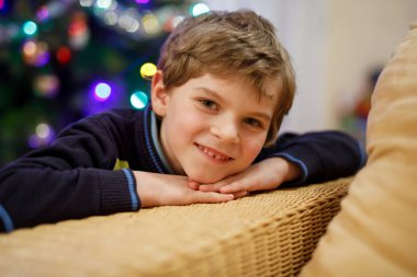 Küçük çocuk ve bir çocuk Noel arifesinde Noel ağacı ışıkları arka plan.