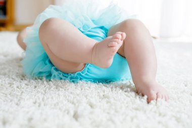 Bacaklar ve ayaklar turkuaz tutu etek giyen beyaz arka plan bebek kız closeup. Gülüyor ve gülümseyen şirin küçük bir çocuk. Mutlu kaygısız bebek. Çocukluk, yeni yaşam konsepti.