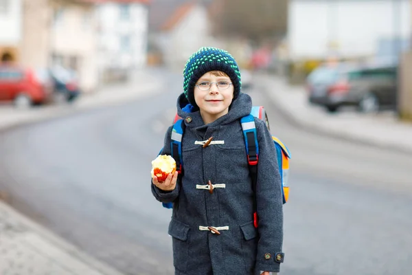 Μικρό παιδί αγόρι με γυαλιά μάτι, με τα πόδια από το σχολείο και διατροφικές apple — Φωτογραφία Αρχείου