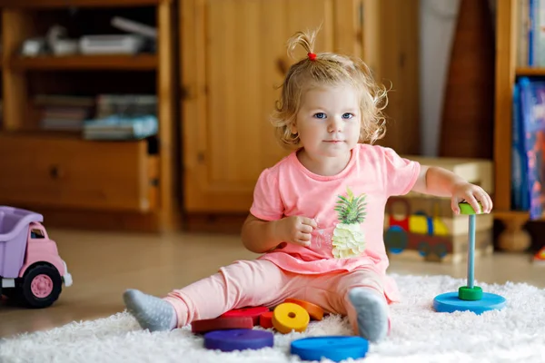 Adorable cute beautiful little baby girl playing with educational colorful wooden rainboy toy pyramid — Stock Photo, Image