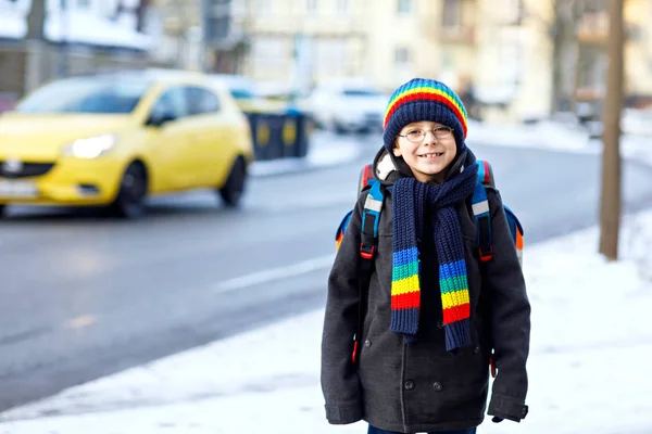 Šťastné dítě chlapec s batoh nebo brašnu, baví se sníh na cestě do školy — Stock fotografie