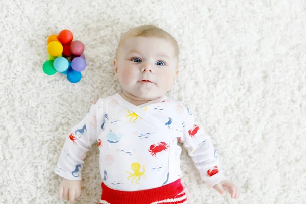 Bonito bebê menina brincando com colorido brinquedo chocalho de madeira — Fotografia de Stock