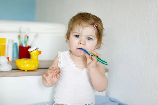 Little baby girl holding toothbrush and brushing first teeth. Toddler learning to clean milk tooth. — Stock Photo, Image