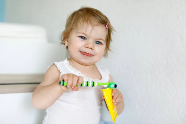 Petite fille tenant une brosse à dents et se brossant les premières dents. Enfant apprenant à nettoyer la dent de lait. — Photo