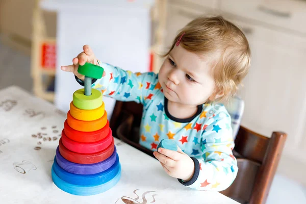 Adorabile carino bella bambina che gioca con educativo piramide giocattolo in legno arcobaleno — Foto Stock