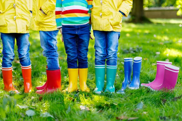 Little kids, boys or girls in jeans and yellow jacket in colorful rain boots — Stock Photo, Image