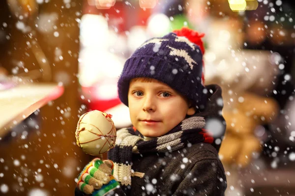 Joyeux enfant mangeant sur la pomme recouverte de chocolat blanc sur le marché de Noël — Photo